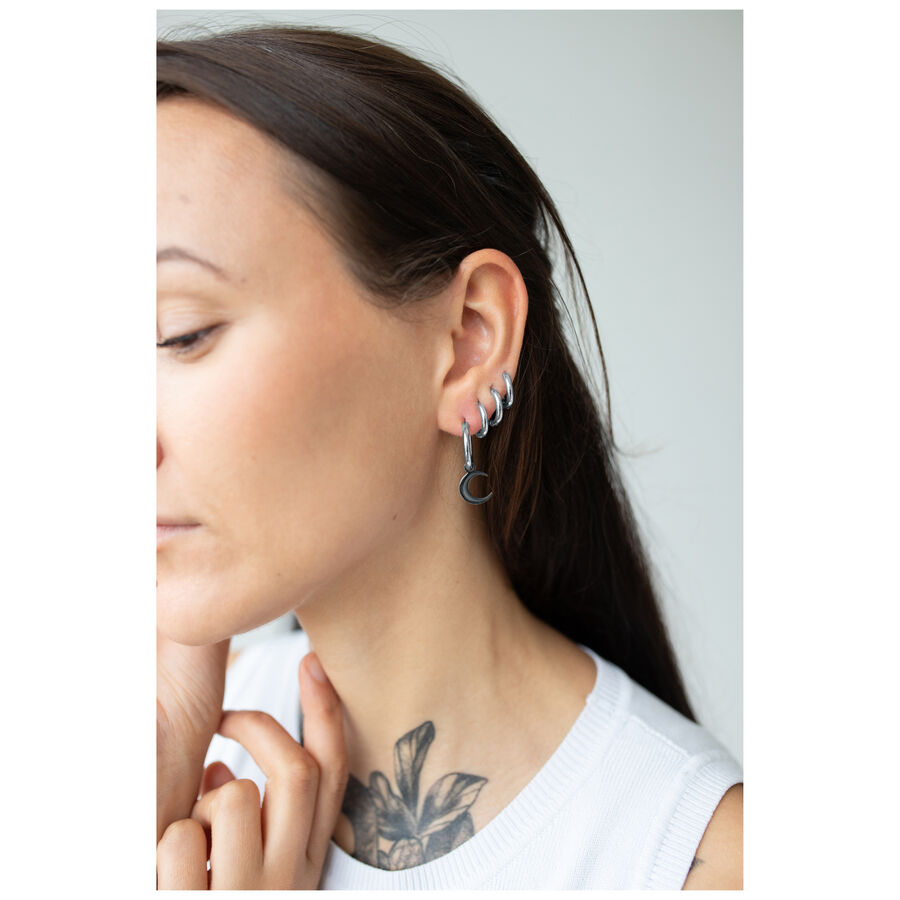 Mujer con Little Moonchild Hoops negros, llevados de lado en la oreja