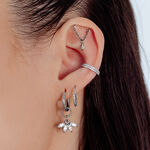 Primo piano di un orecchio con diversi piercing in argento, incluso un accessorio Helix con piccoli cristalli.