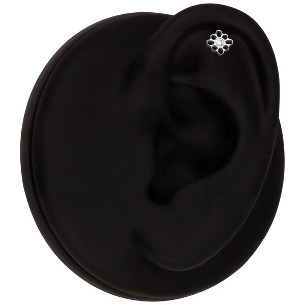 Modello di orecchio nero con piercing floreale in oro bianco nella zona dell'elica