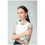 Mujer con pendientes Cathedral Hoops negros de acero inoxidable frente a un fondo gris