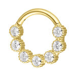 Anello piercing dorato con sette scintillanti pietre di moissanite su sfondo bianco