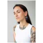 Mujer con cabello largo lleva aros Dahlia de plata sobre fondo gris