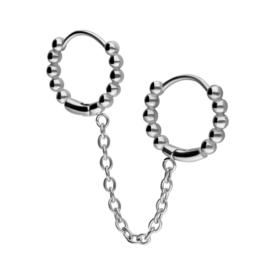 Orecchini a cerchio doppi Huggie in argento con sfere e catena su sfondo bianco