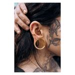 Persona con Barbell Triplet dorado y otros piercings en la oreja