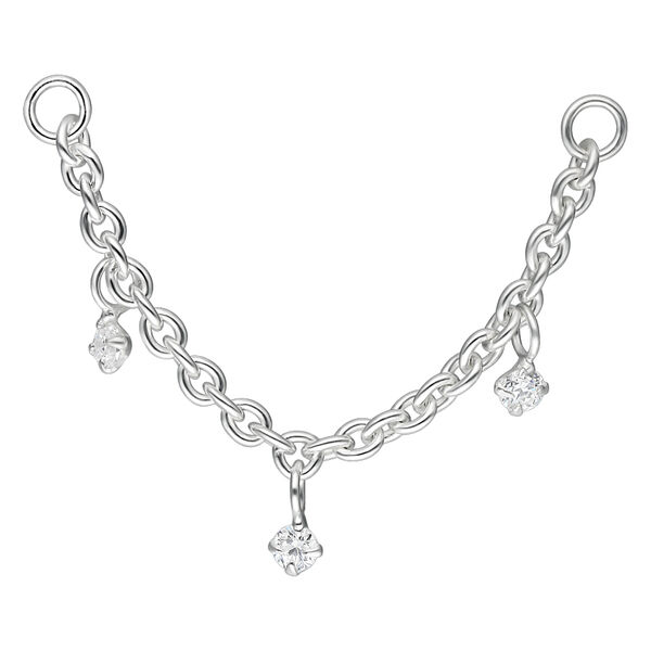 Cadena de piercing plateada con tres colgantes de cristal claro sobre fondo blanco