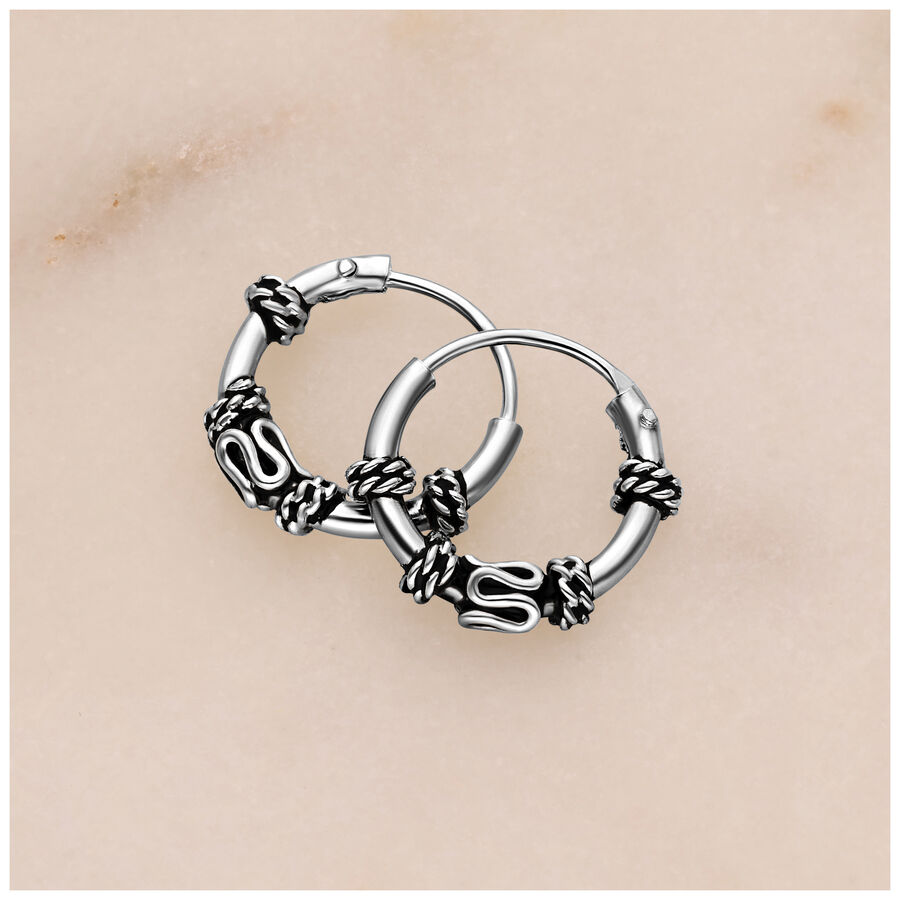 Aros de plata con detalles de nudo sobre fondo claro