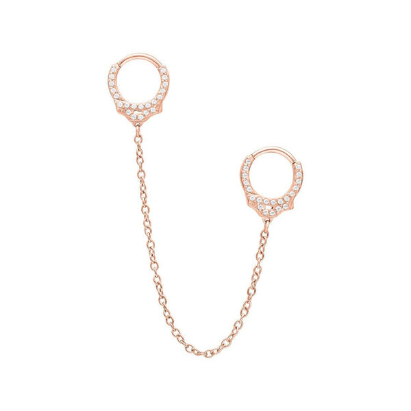Roségoldene Piercingringe mit Glitzersteinen und Kette auf weißem Hintergrund
